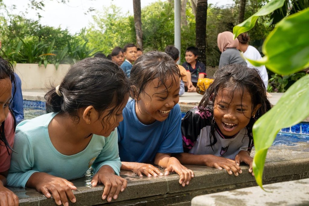 Local children participating in a small-group swim lesson with instructor supervision.